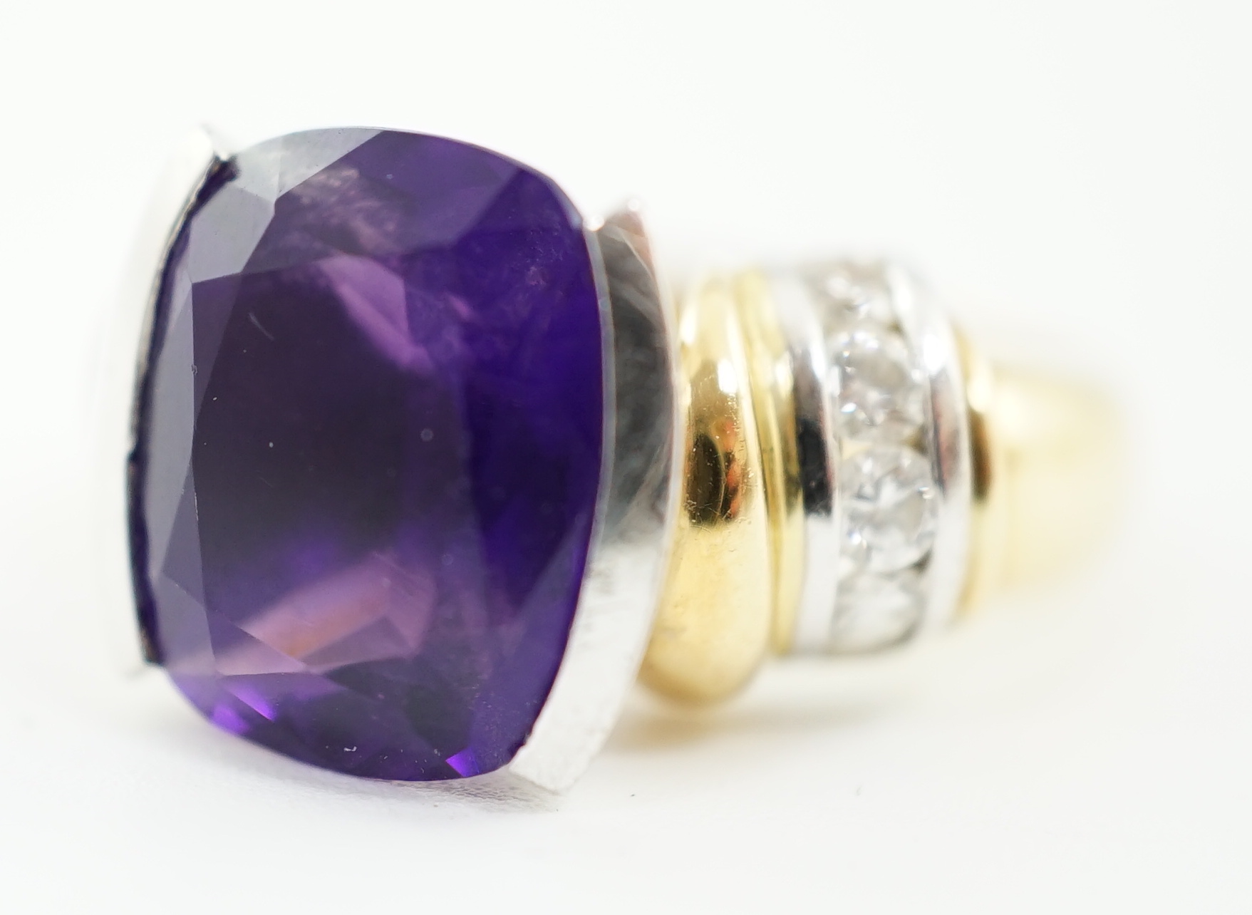 A modern 18ct gold and single stone cushion cut amethyst set dress ring, with ten stone round brilliant cut diamond set shoulders